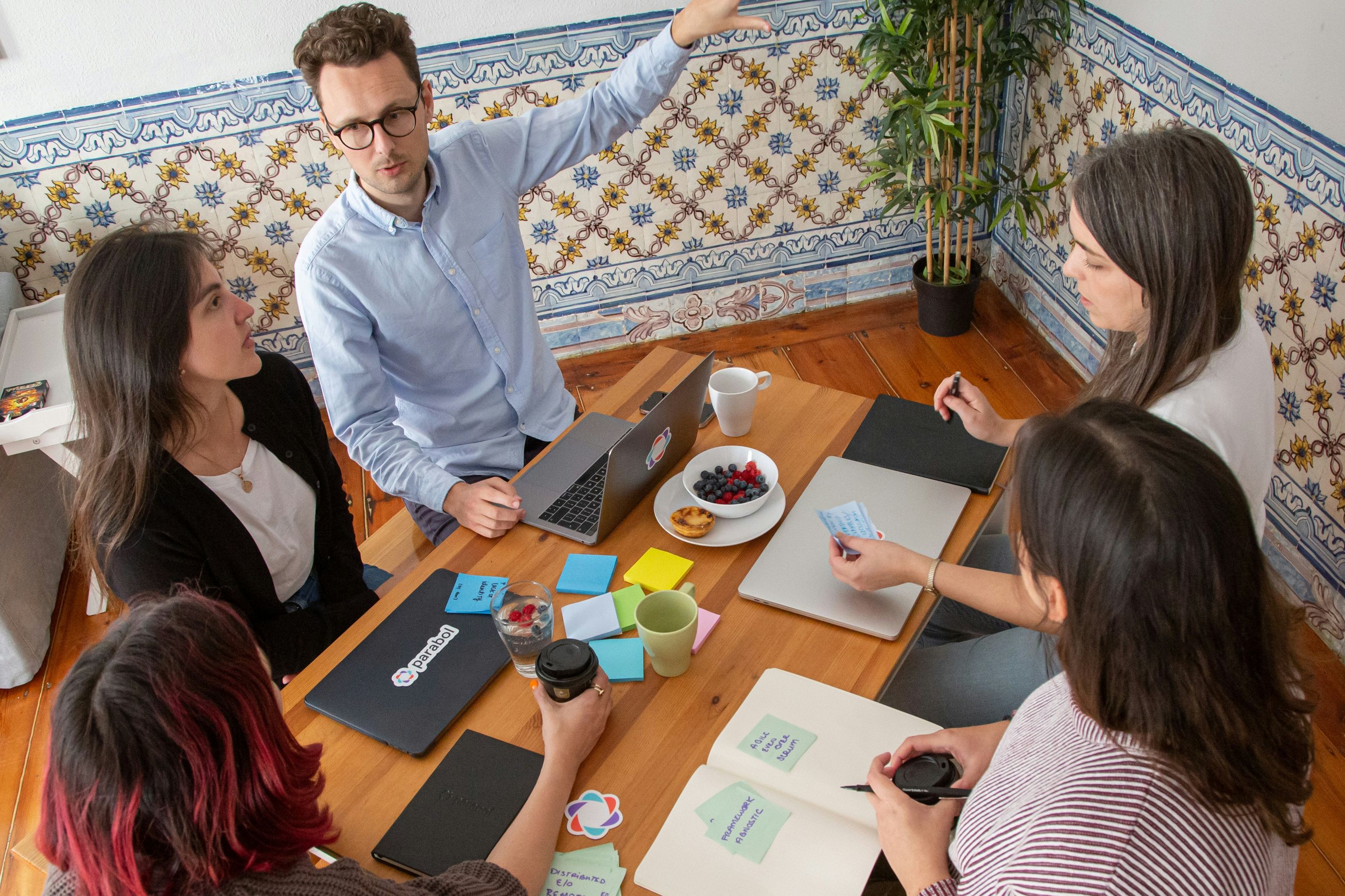 5 people sat at a table having a meeting