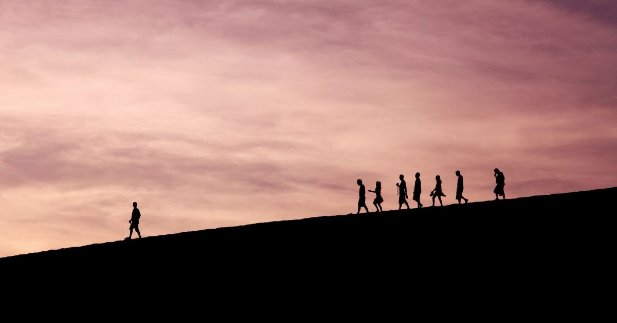 A man leading his friends down a hill