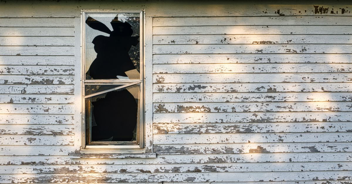 A run-down house with a broken window