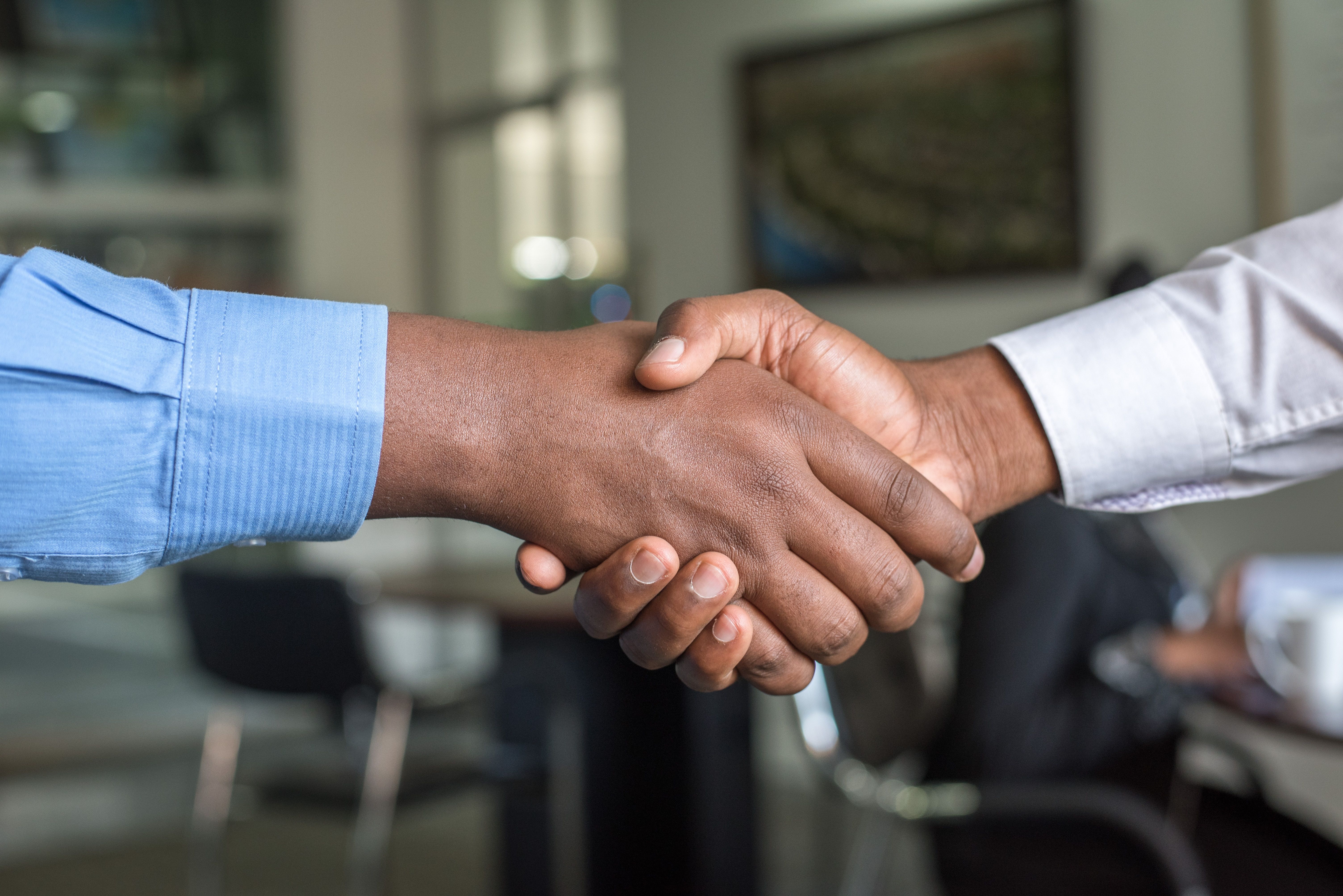 close up of two people shaking hands to close a deal