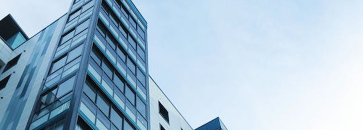 A close-up of the facade of a tall building with many windows and its geometric pattern revealed