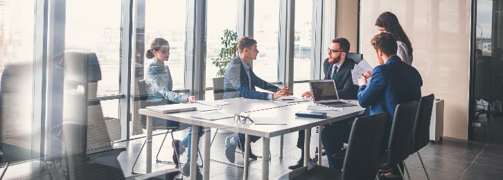 A group of colleagues collaborate on a presentation in a conference room