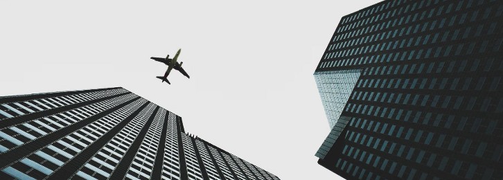 A beautiful and breathtaking view of an airplane flying over a tall building