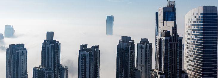 A peaceful and serene view of a cityscape with skyscrapers crossing clouds