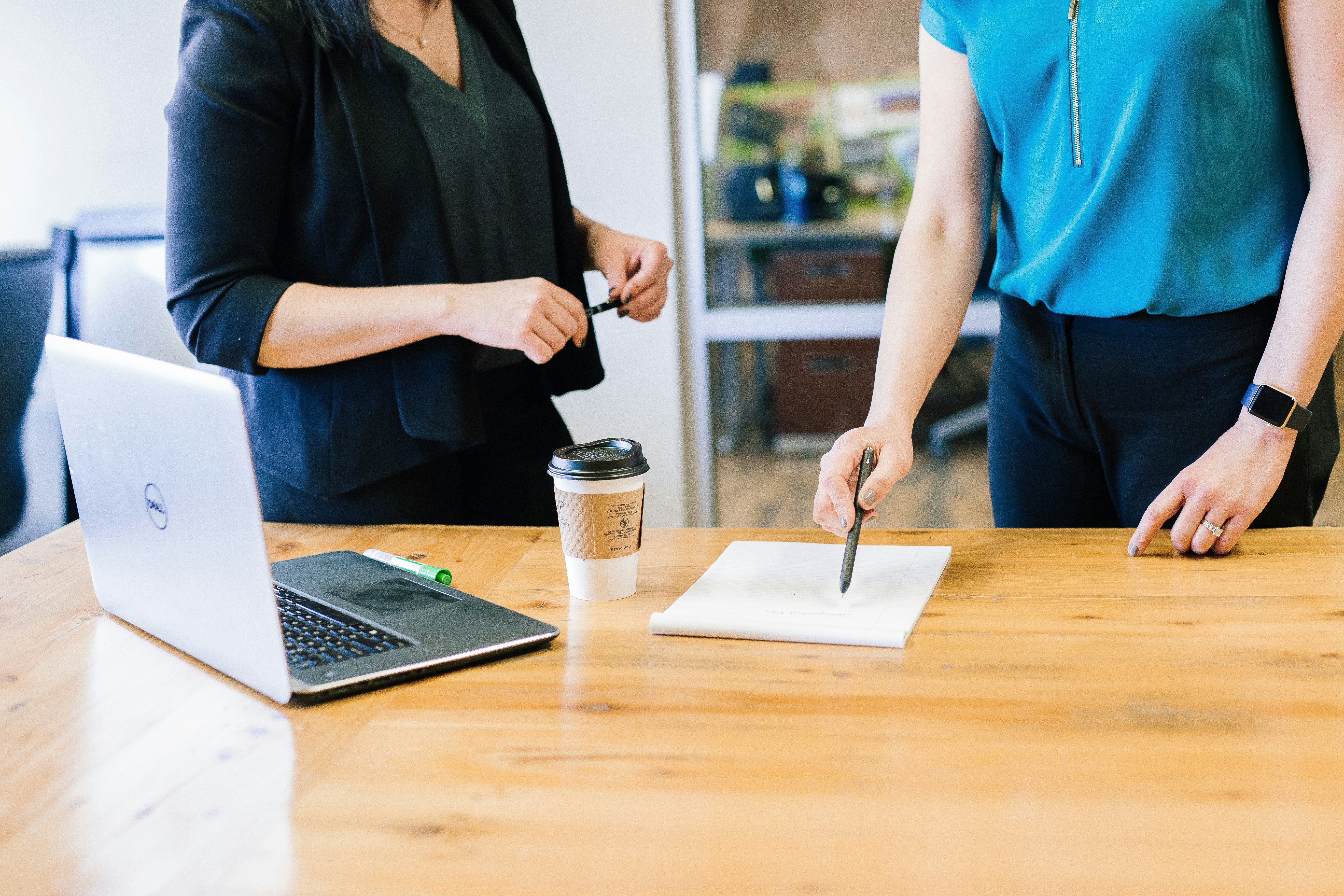 Two women discussing a deal over a desk